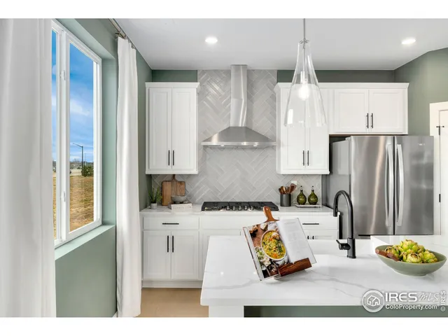 a kitchen with stainless steel appliances kitchen island granite countertop a refrigerator and a sink