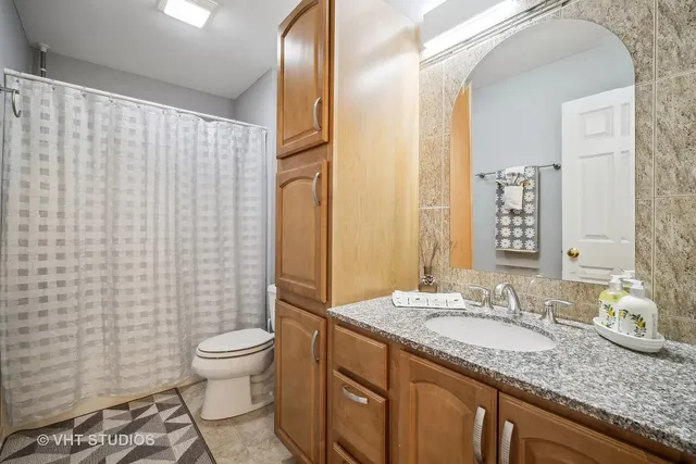 a bathroom with a granite countertop sink toilet and shower