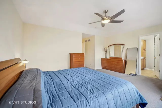 a bedroom with a large bed and a chandelier