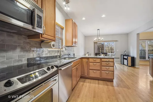 a large kitchen with stainless steel appliances granite countertop a stove and a sink