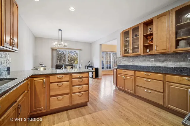 a kitchen with stainless steel appliances granite countertop a stove a sink and a granite counter tops with wooden floors