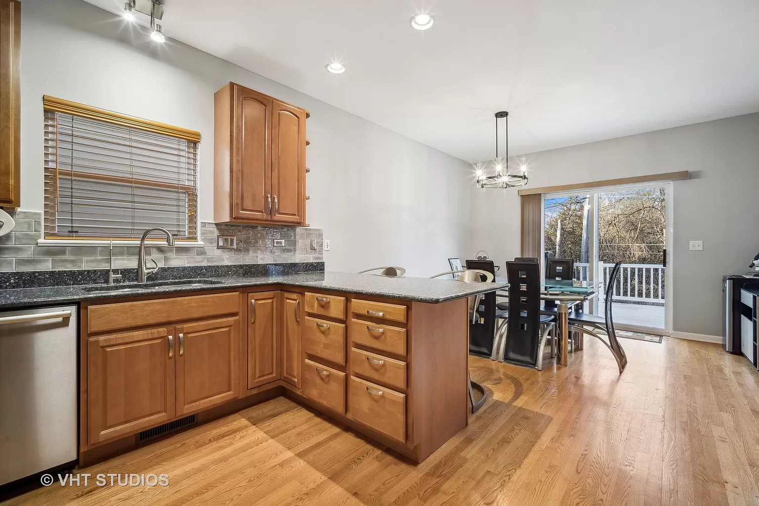 23540 North Melody Lane Lake Zurich, IL 60047 - Photo 5 of 35 a kitchen with stainless steel appliances granite countertop a stove top oven a sink dishwasher a dining table and chairs with wooden floor