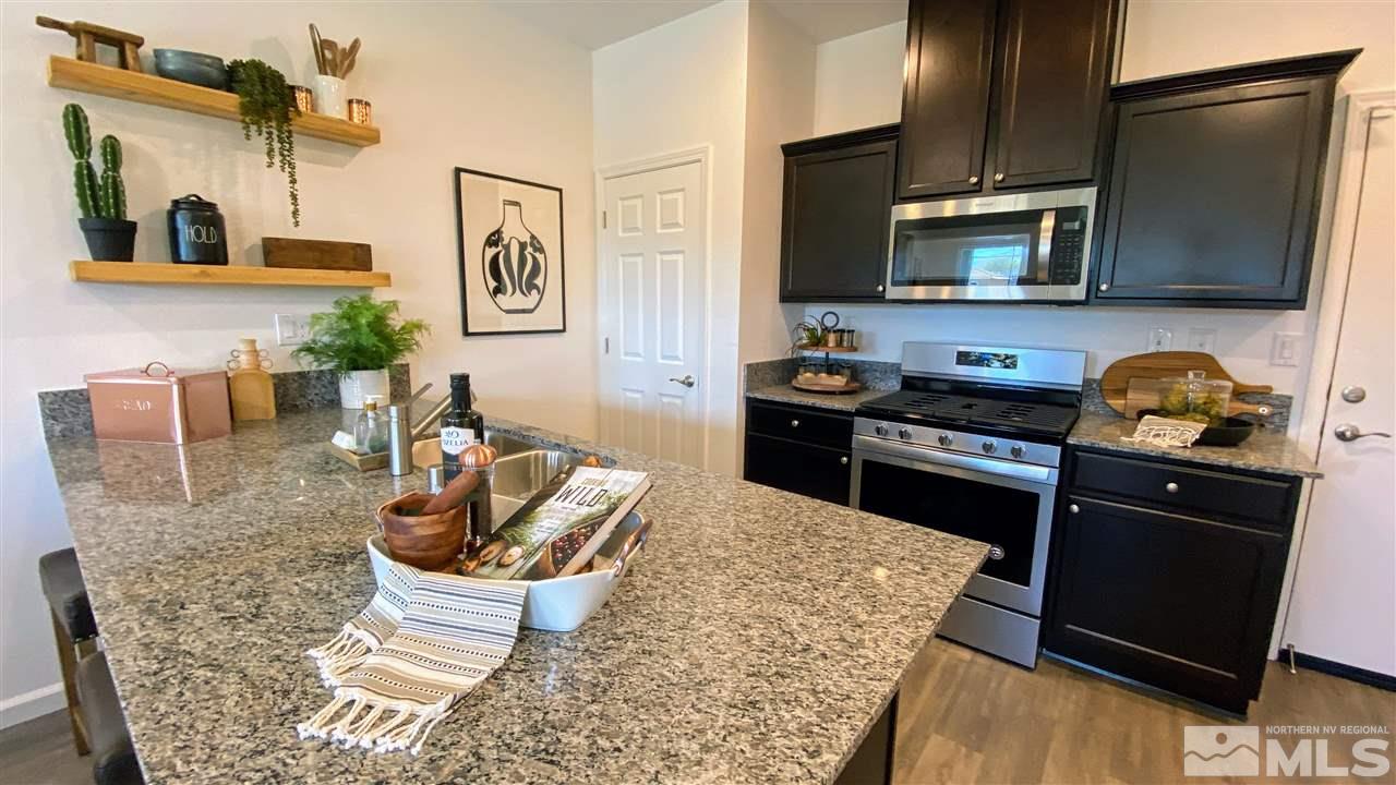 400 Autumn Breeze Circle, Unit LOT #1 Reno, NV 89511 - Photo 6 of 23 a kitchen with stainless steel appliances granite countertop a stove top oven a sink a dining table and chairs with wooden floor