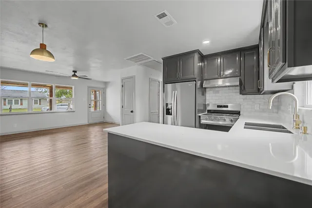 a kitchen with stainless steel appliances a refrigerator sink and cabinets