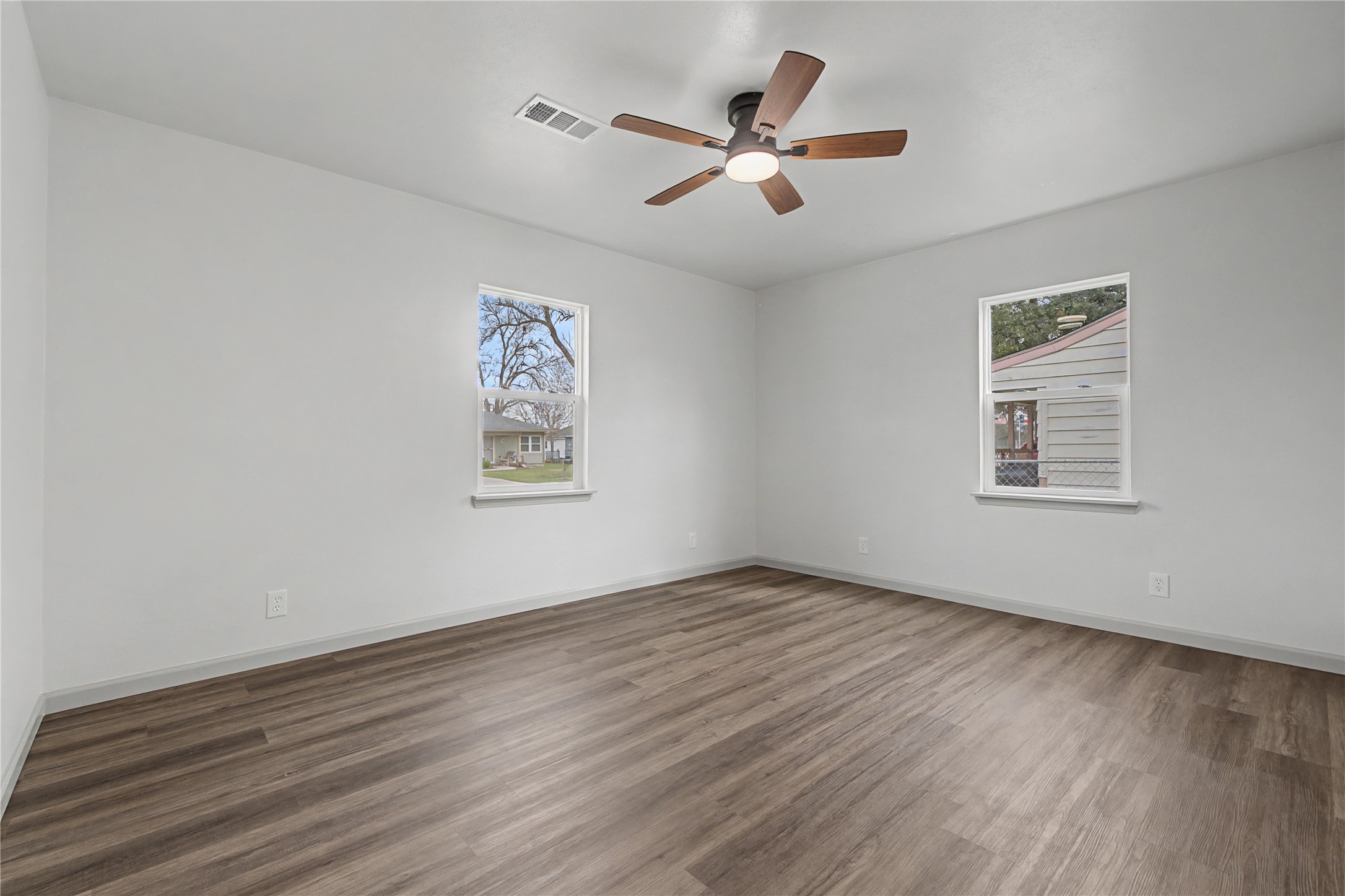 1108 Nottingham Drive Angleton, TX 77515 - Photo 14 of 27 a view of a big room with wooden floor a ceiling fan and windows