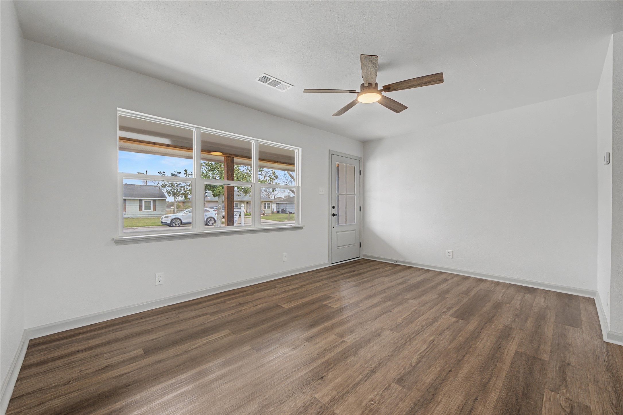 1108 Nottingham Drive Angleton, TX 77515 - Photo 4 of 27 an empty room with wooden floor ceiling fan and windows
