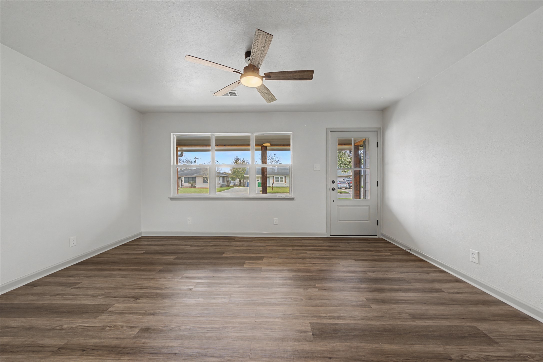 1108 Nottingham Drive Angleton, TX 77515 - Photo 6 of 27 a view of an empty room with wooden floor and a window