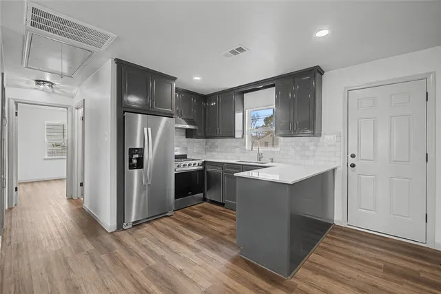 a kitchen with a refrigerator sink and cabinets