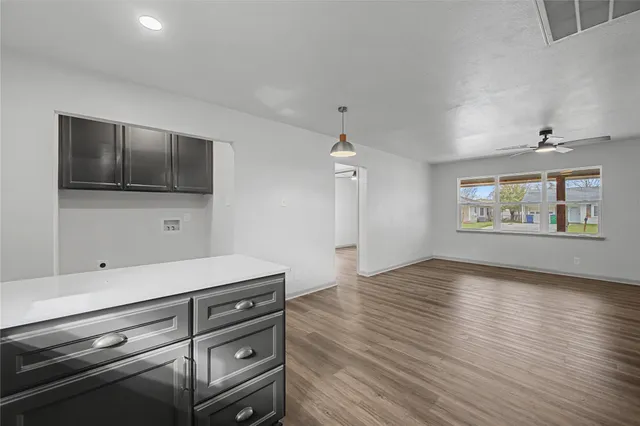 an empty room with wooden floor cabinet and flat screen tv