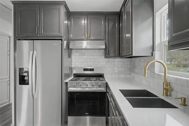 a kitchen with granite countertop a refrigerator and a stove