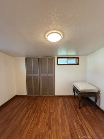 a view of a room with wooden floor ceiling fan and a window
