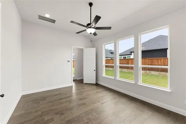a view of an empty room with a window and a ceiling fan