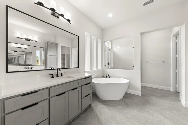 a spacious bathroom with a double vanity sink mirror and bathtub