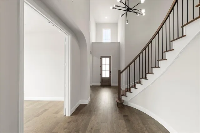 a view of staircase with wooden floor and fan