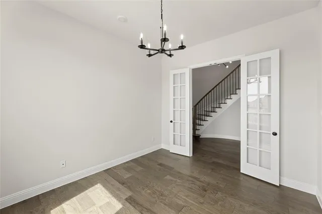 a view of empty room with wooden floor and ceiling fan