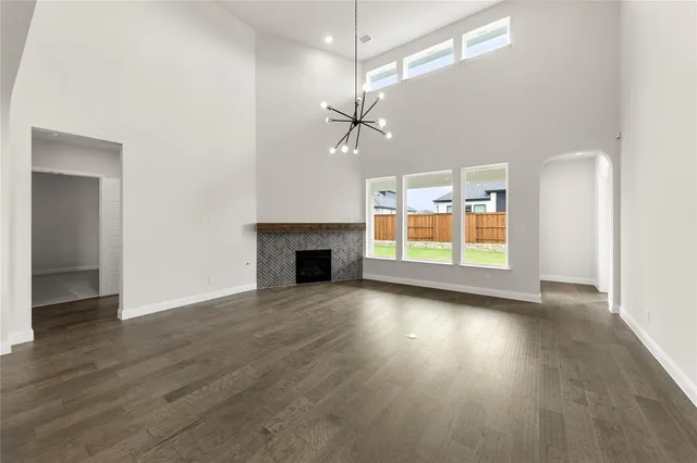 an empty room with wooden floor ceiling fan and windows