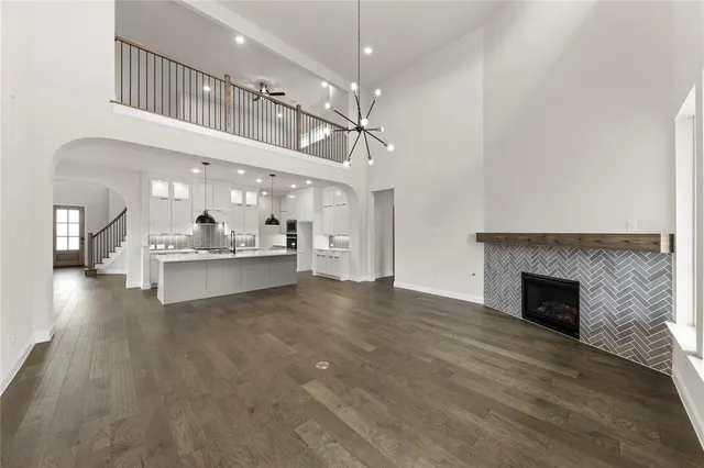 a view of an empty room with kitchen and a fireplace
