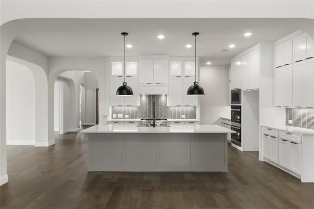 a large kitchen with kitchen island a sink stainless steel appliances and cabinets