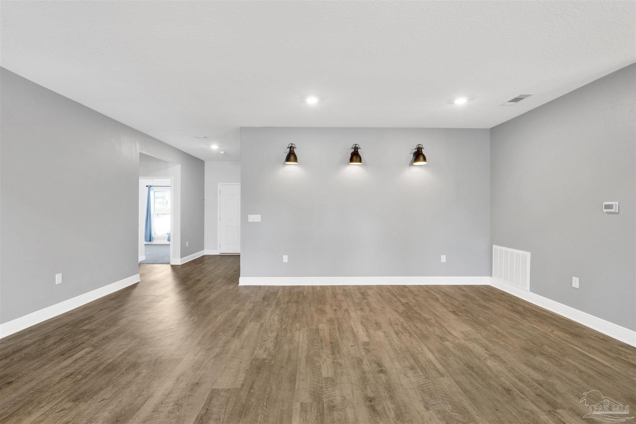 7907 Majestic Cypress Drive Milton, FL 32583 - Photo 11 of 36 a view of an empty room with wooden floor