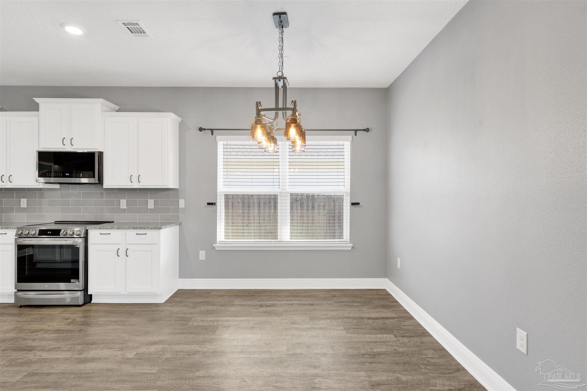 7907 Majestic Cypress Drive Milton, FL 32583 - Photo 12 of 36 a view of an empty room with a kitchen and a window