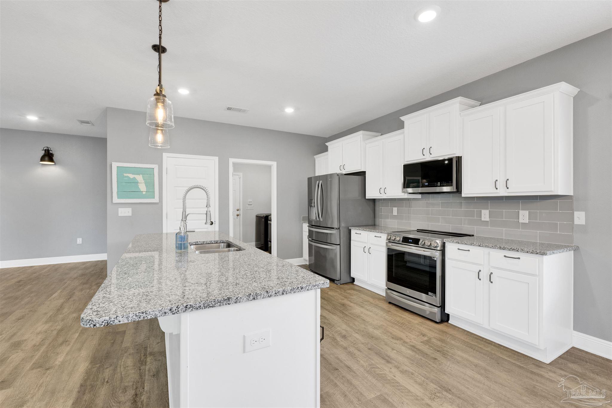 7907 Majestic Cypress Drive Milton, FL 32583 - Photo 14 of 36 a kitchen with granite countertop a sink a counter top space stainless steel appliances and cabinets