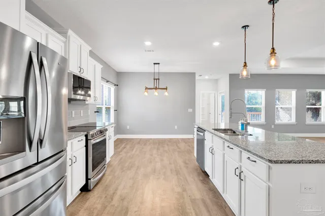 a kitchen with stainless steel appliances granite countertop a sink stove and refrigerator