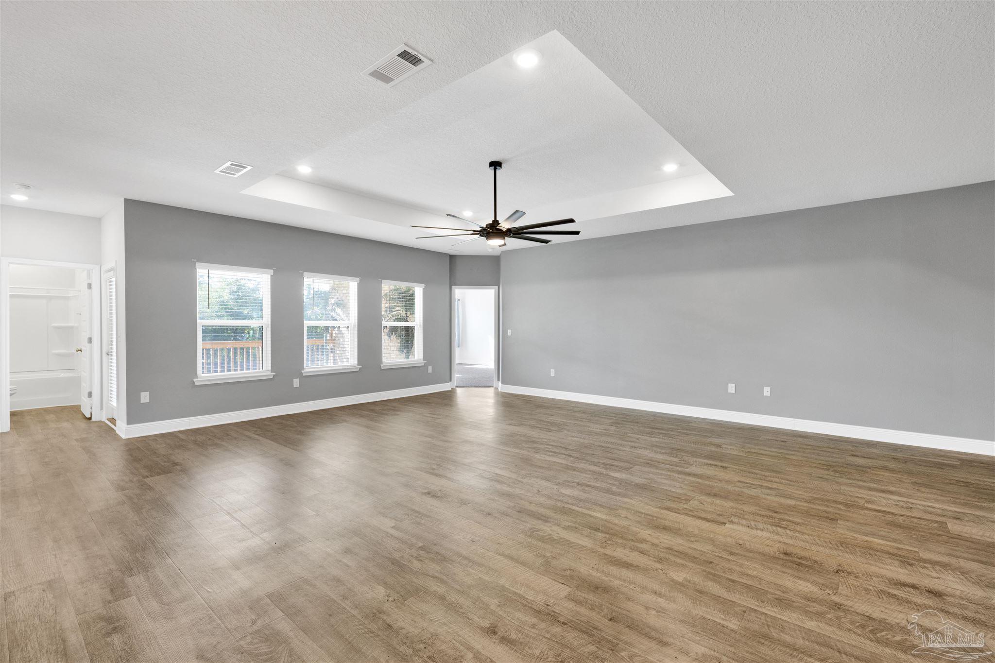 7907 Majestic Cypress Drive Milton, FL 32583 - Photo 18 of 36 a view of an empty room with window and wooden floor