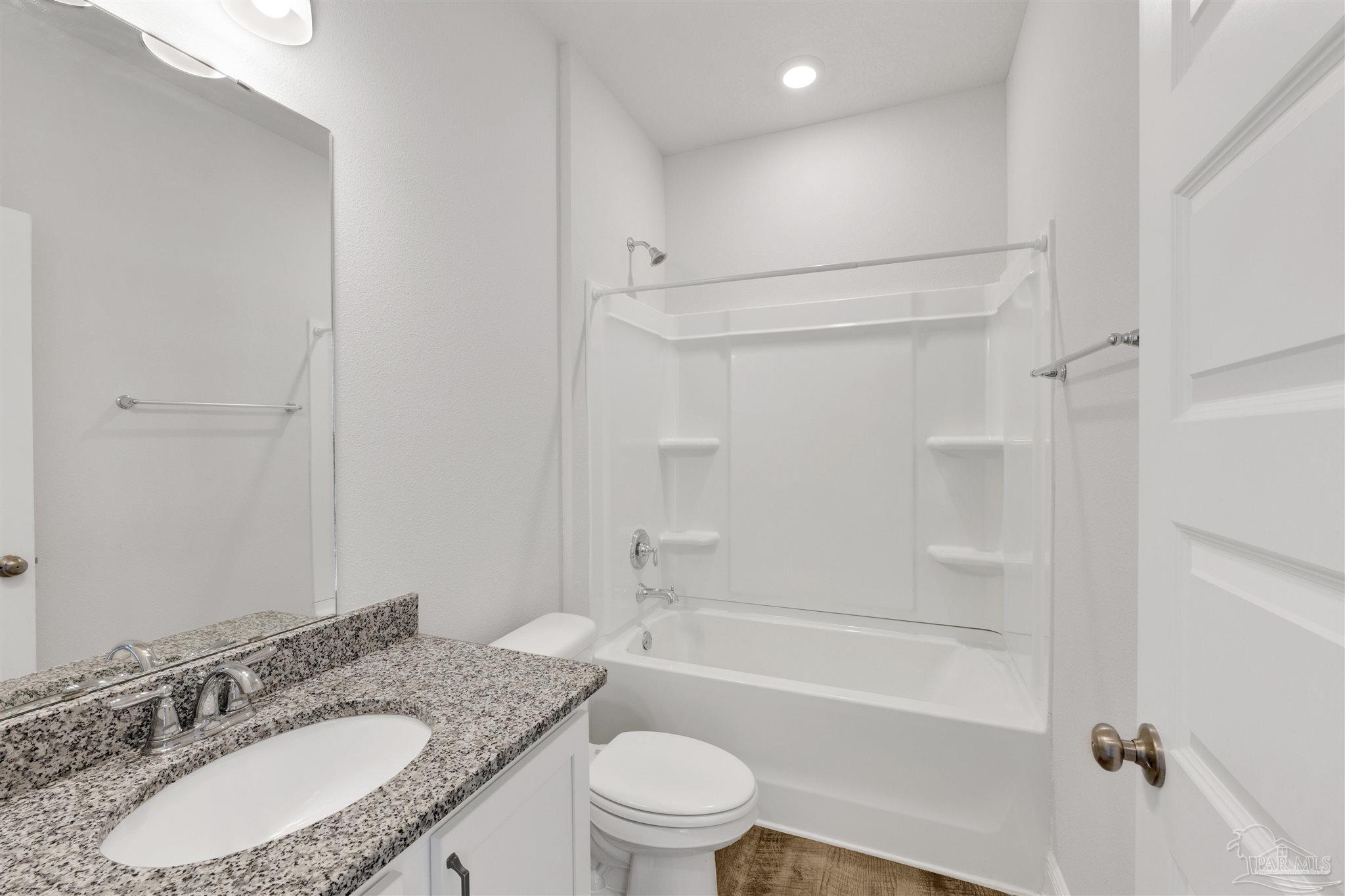 7907 Majestic Cypress Drive Milton, FL 32583 - Photo 20 of 36 a bathroom with a granite countertop sink toilet mirror and shower