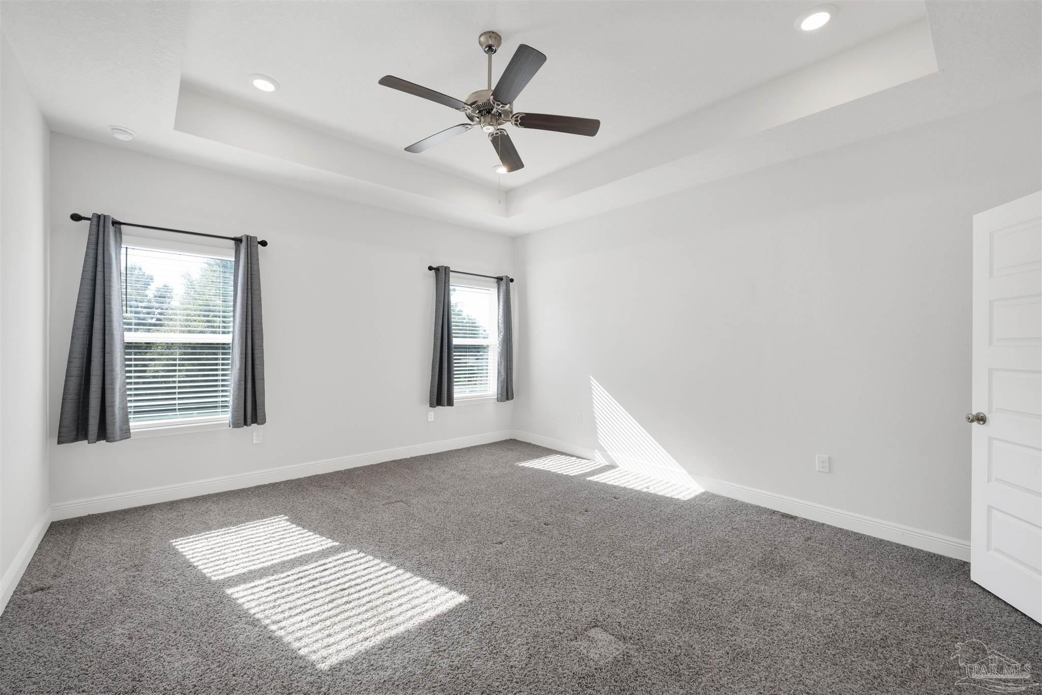 7907 Majestic Cypress Drive Milton, FL 32583 - Photo 21 of 36 an empty room with windows and fan