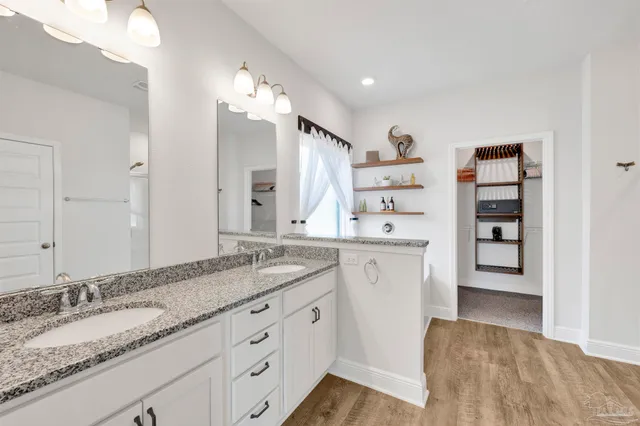 a spacious bathroom with a granite countertop sink and a mirror