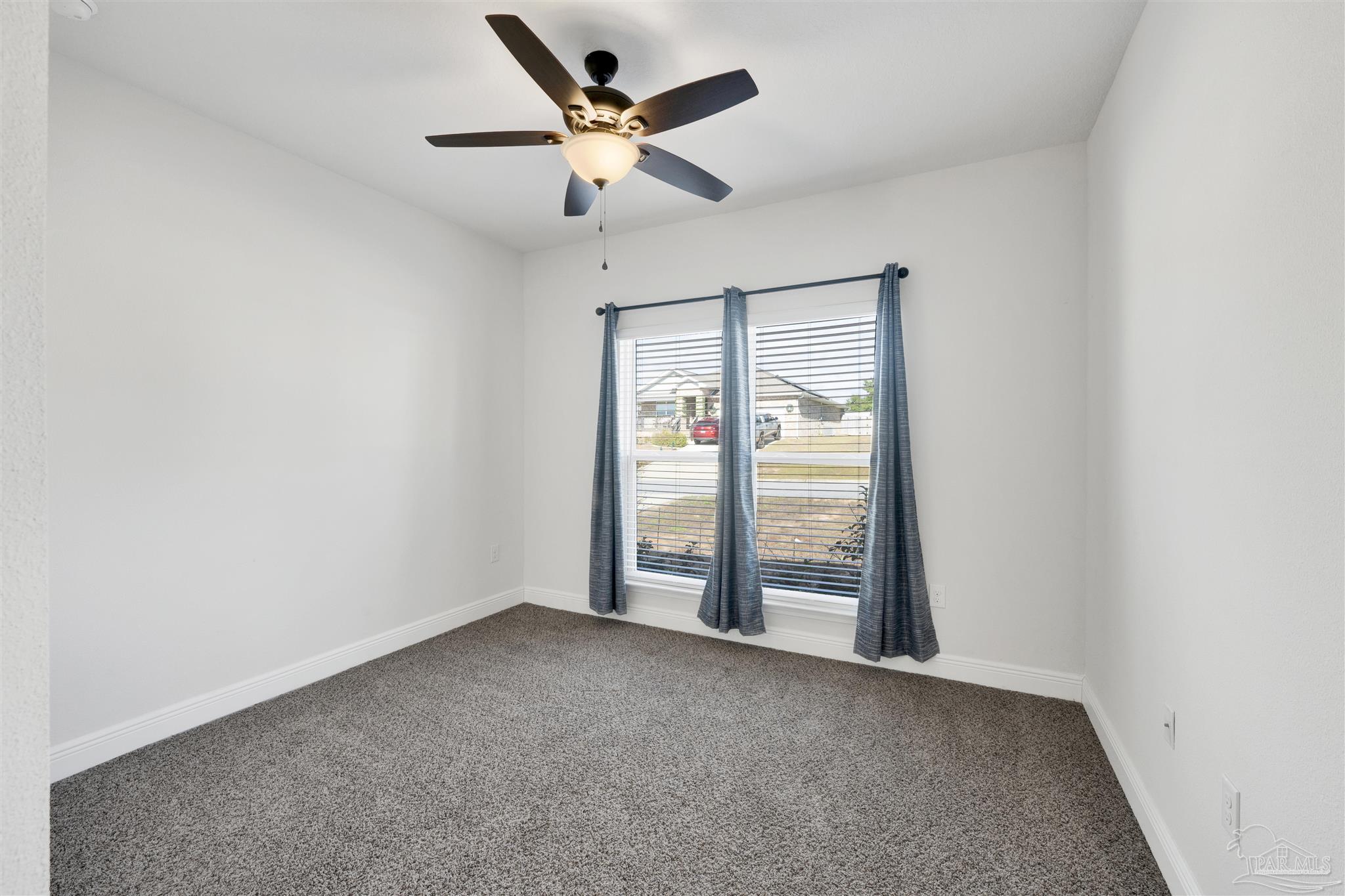 7907 Majestic Cypress Drive Milton, FL 32583 - Photo 26 of 36 an empty room with windows and fan
