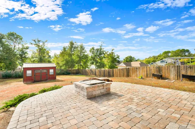 a swimming pool with yard and trees in the background