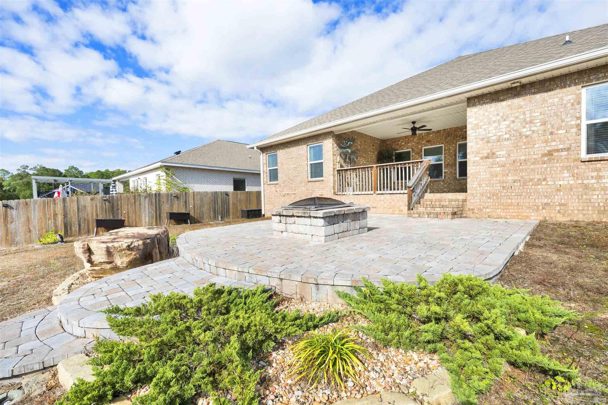 7907 Majestic Cypress Drive Milton, FL 32583 - Photo 32 of 36 a patio with a table and chairs and potted plants