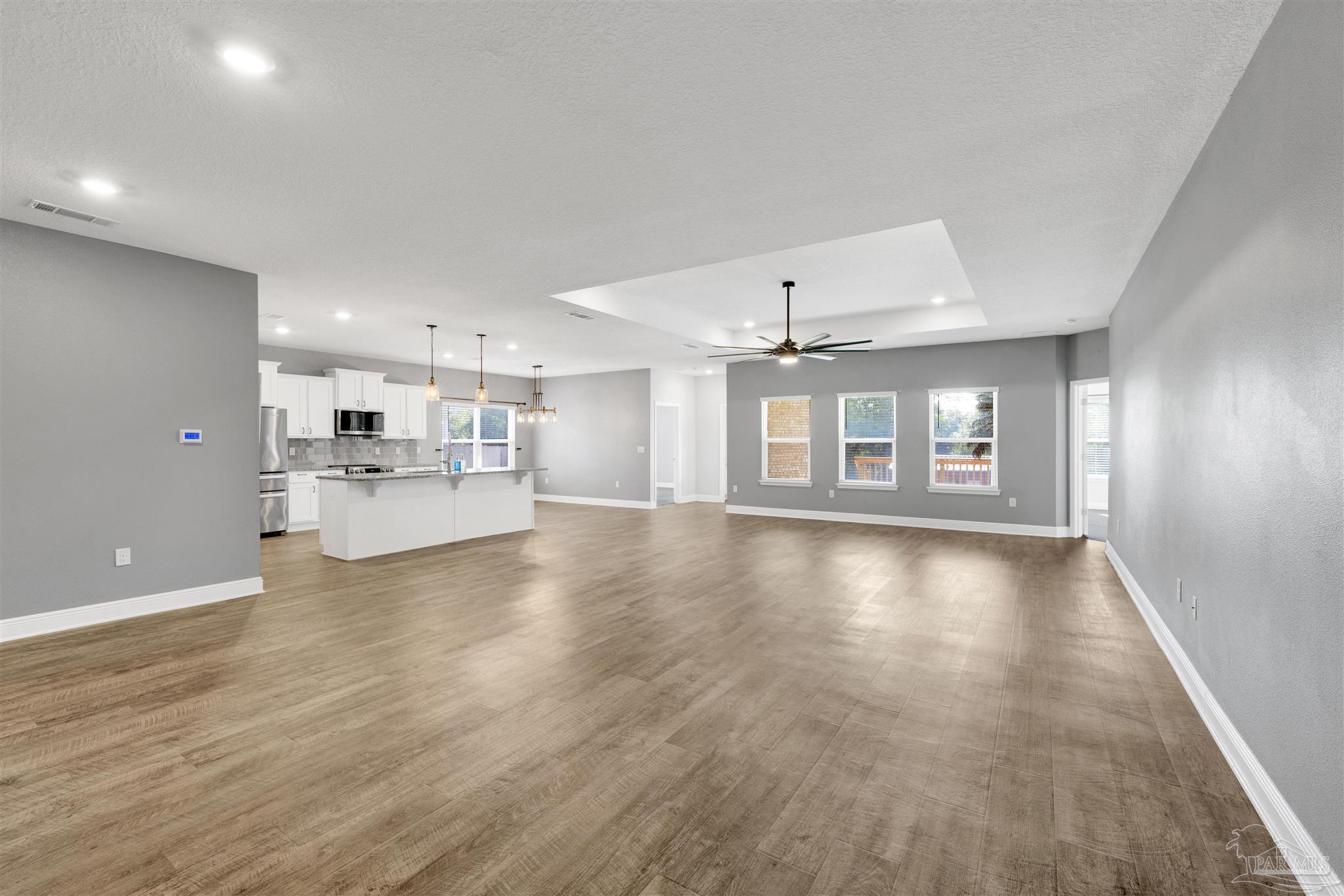 7907 Majestic Cypress Drive Milton, FL 32583 - Photo 7 of 36 a view of an empty room with window and wooden floor