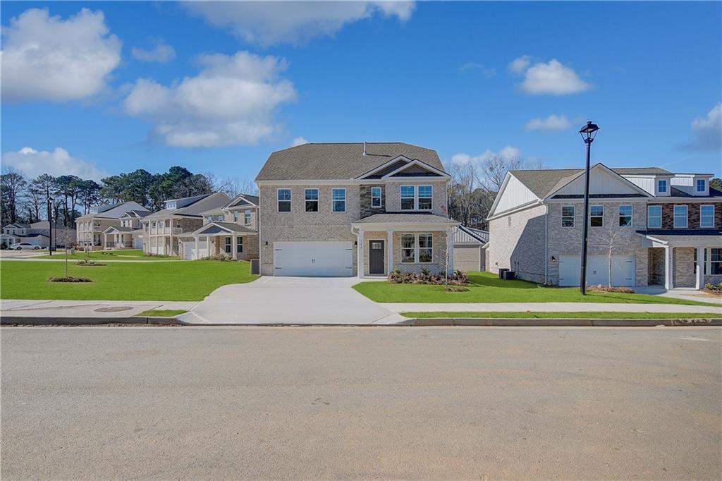 a front view of a house with a big yard and potted plants