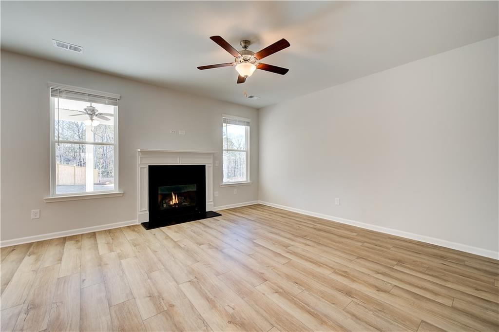 143 Dalston Cove Stockbridge, GA 30281 - Photo 9 of 32 an empty room with windows and a ceiling fan