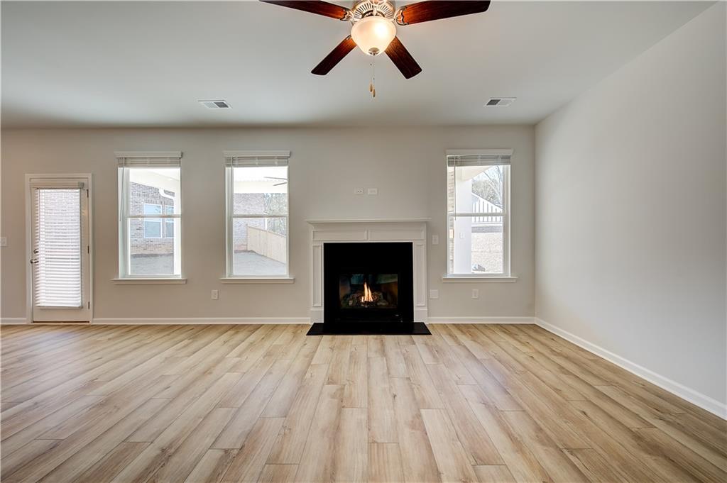 143 Dalston Cove Stockbridge, GA 30281 - Photo 10 of 32 a view of an empty room with wooden floor fireplace and a window