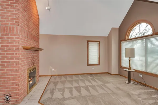 a view of an empty room with a fireplace and a window