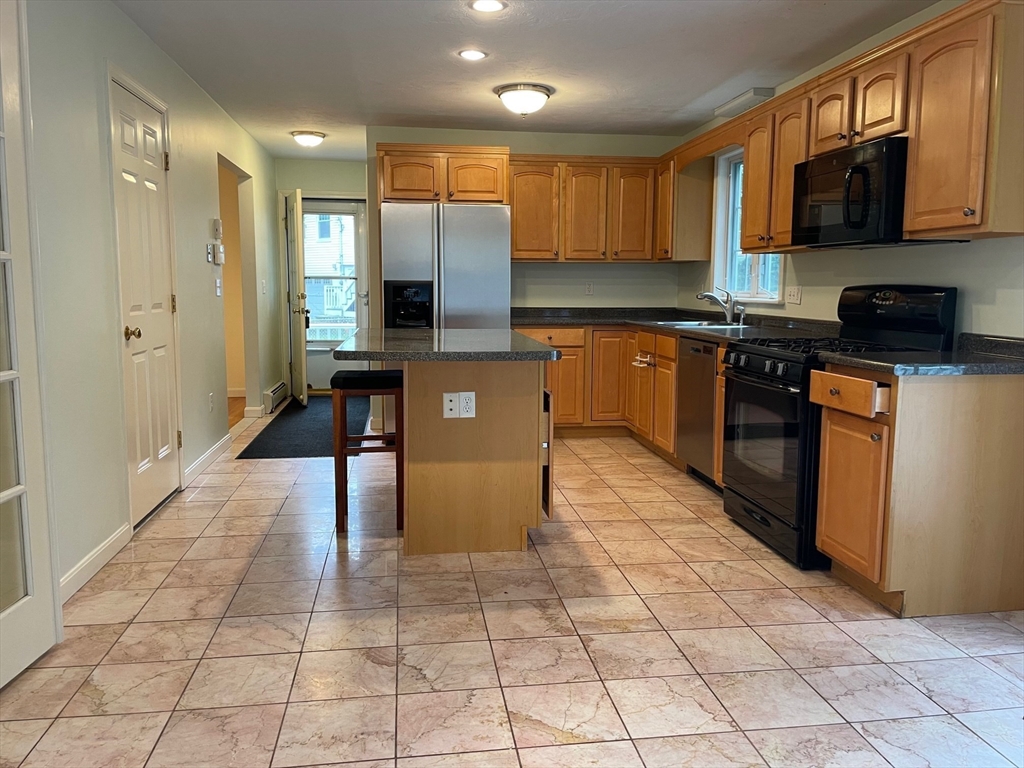 72 Cedar Road North Medford, MA 02155 - Photo 6 of 19 a kitchen with stainless steel appliances granite countertop a stove a sink and a microwave