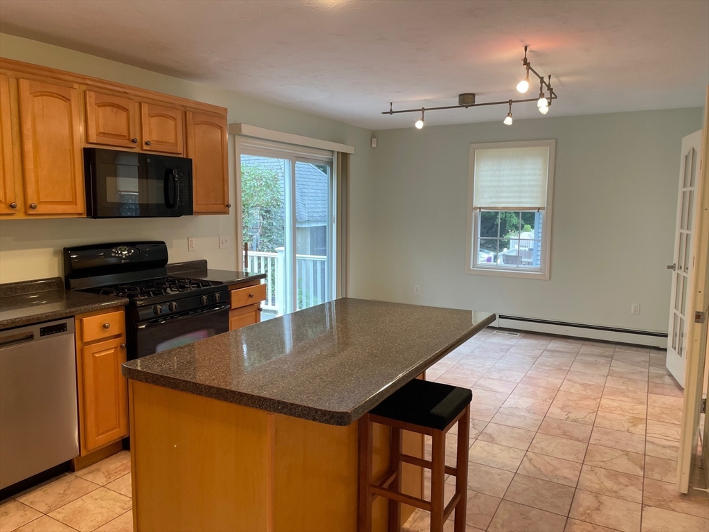 72 Cedar Road North Medford, MA 02155 - Photo 8 of 19 a kitchen with granite countertop a stove a sink dishwasher and a microwave with wooden floor