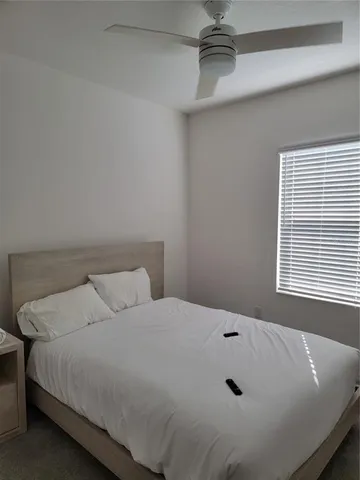 a bed sitting in a bedroom next to a window