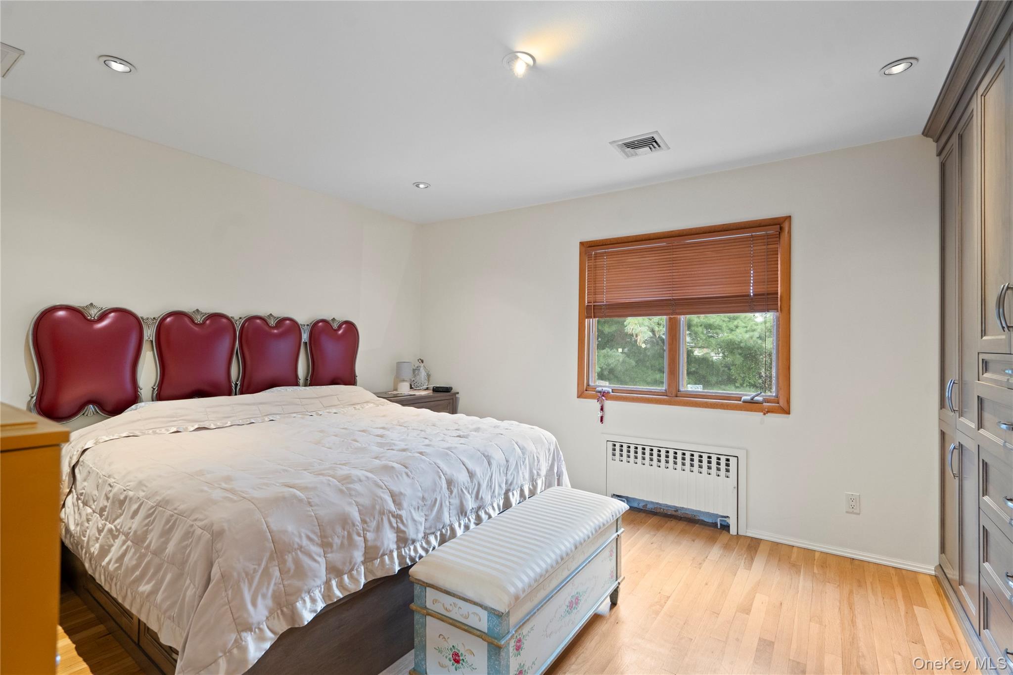 33 Shelter Hill Road Plainview, NY 11803 - Photo 15 of 34 Bedroom featuring light wood-style flooring, radiator heating unit, and recessed lighting