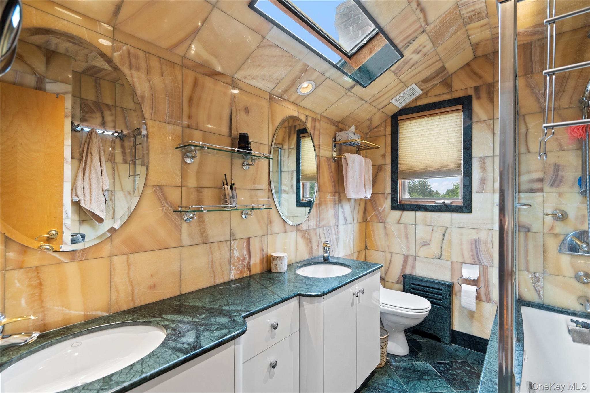 33 Shelter Hill Road Plainview, NY 11803 - Photo 17 of 34 Full bath featuring tile walls, double vanity, a skylight, an enclosed shower, and vaulted ceiling