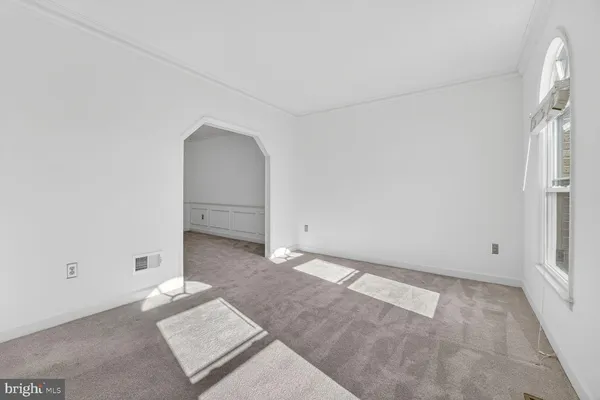 a view of an empty room with stairs and a window