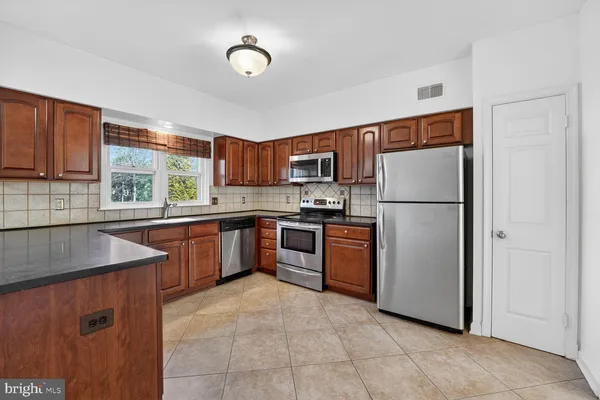 a kitchen with stainless steel appliances granite countertop a sink and cabinets