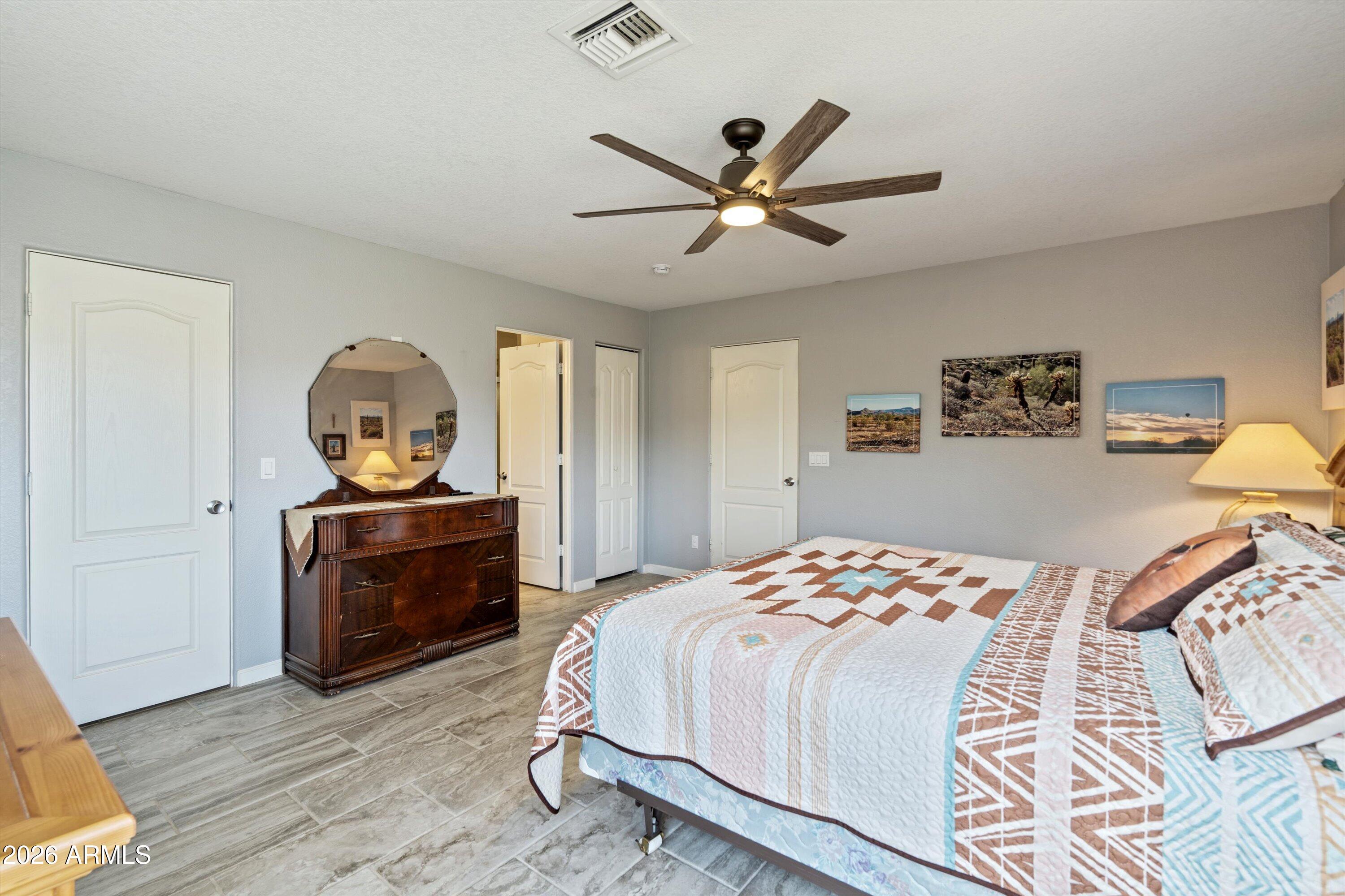 2316 West White Spar Road New River, AZ 85087 - Photo 15 of 40 a bedroom with a bed and wooden floor