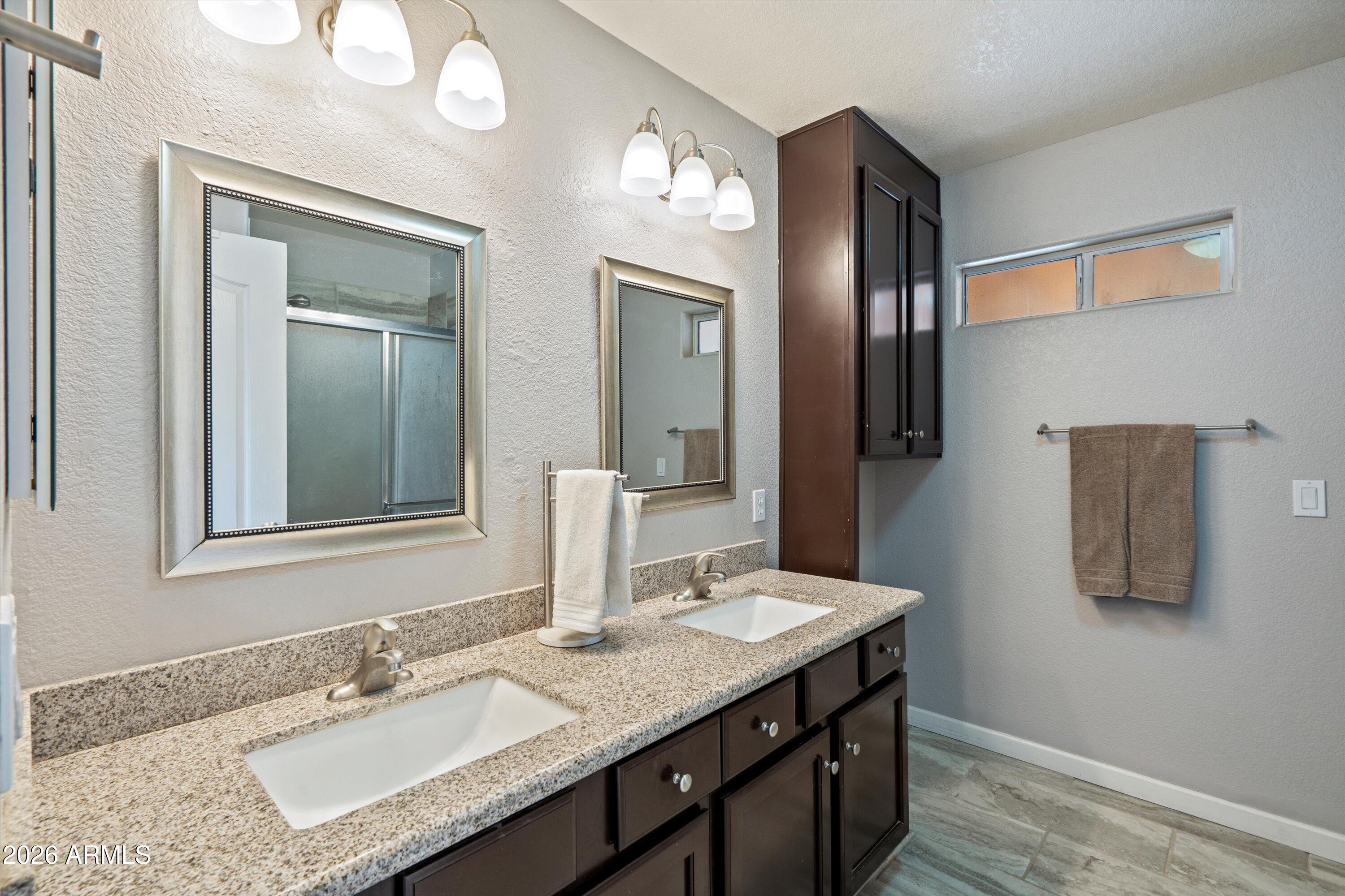 2316 West White Spar Road New River, AZ 85087 - Photo 16 of 40 a bathroom with a granite countertop sink and a mirror