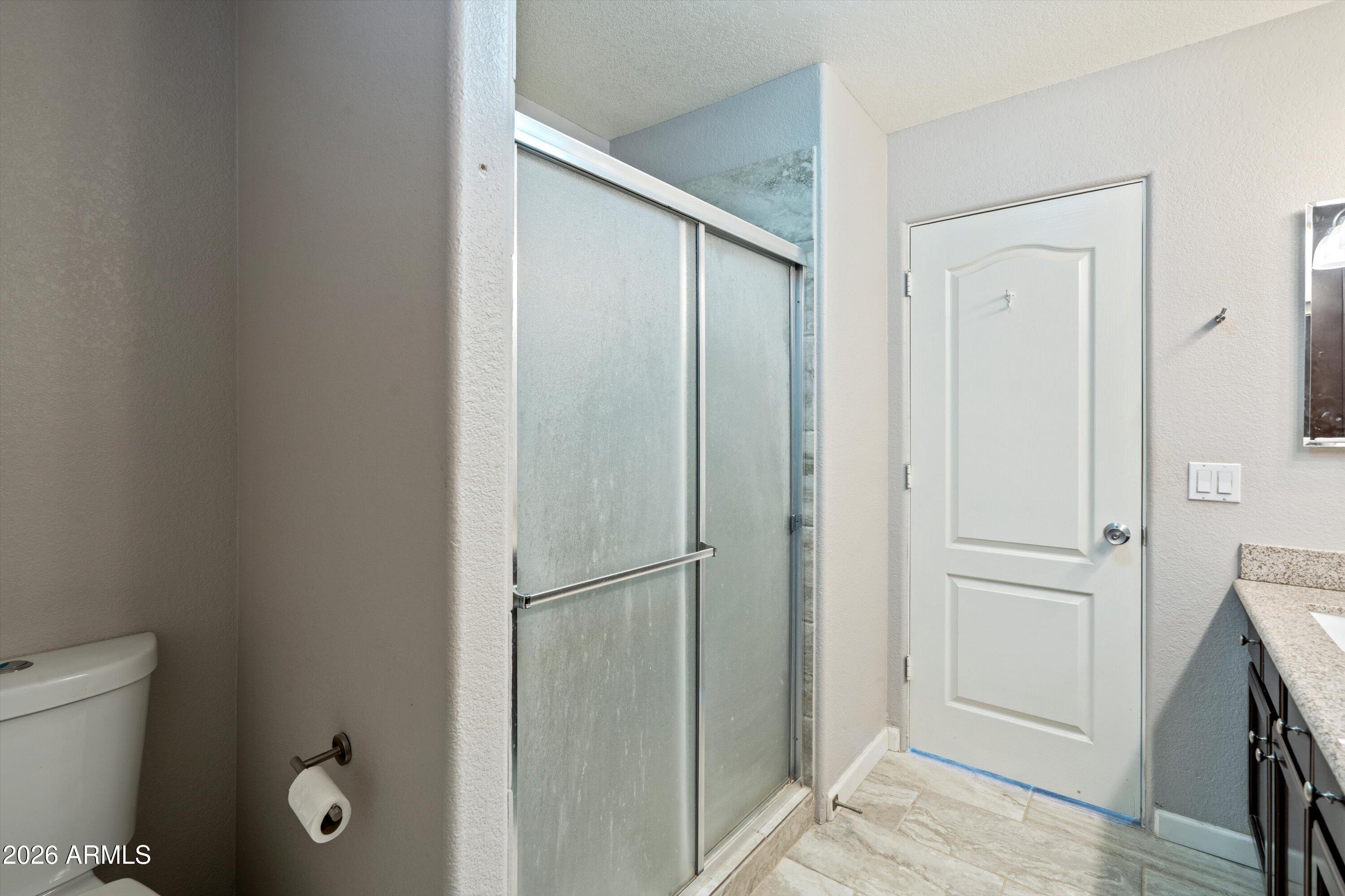 2316 West White Spar Road New River, AZ 85087 - Photo 17 of 40 a bathroom with a glass shower door
