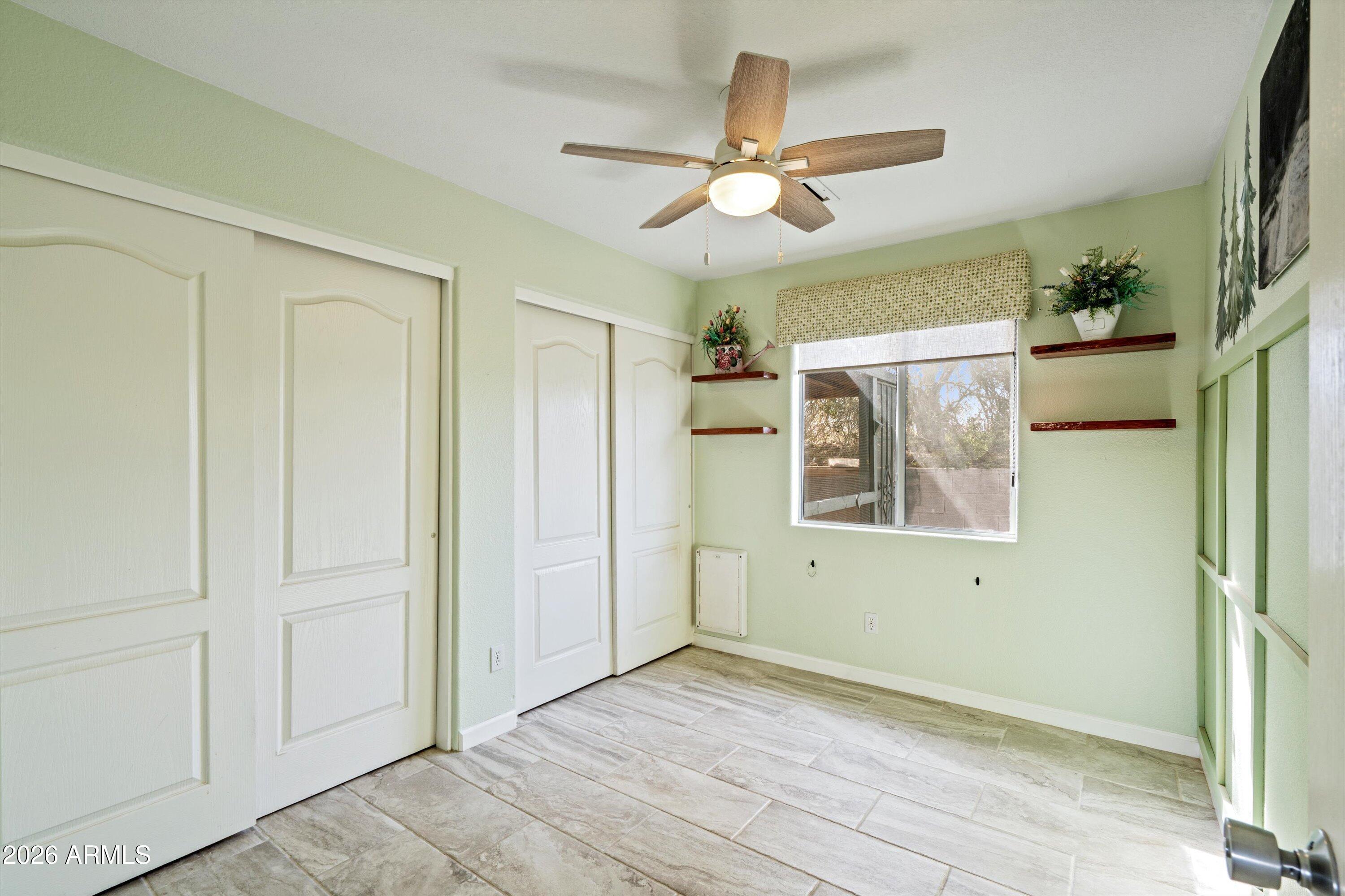 2316 West White Spar Road New River, AZ 85087 - Photo 19 of 40 an empty room with wooden floor fan and windows