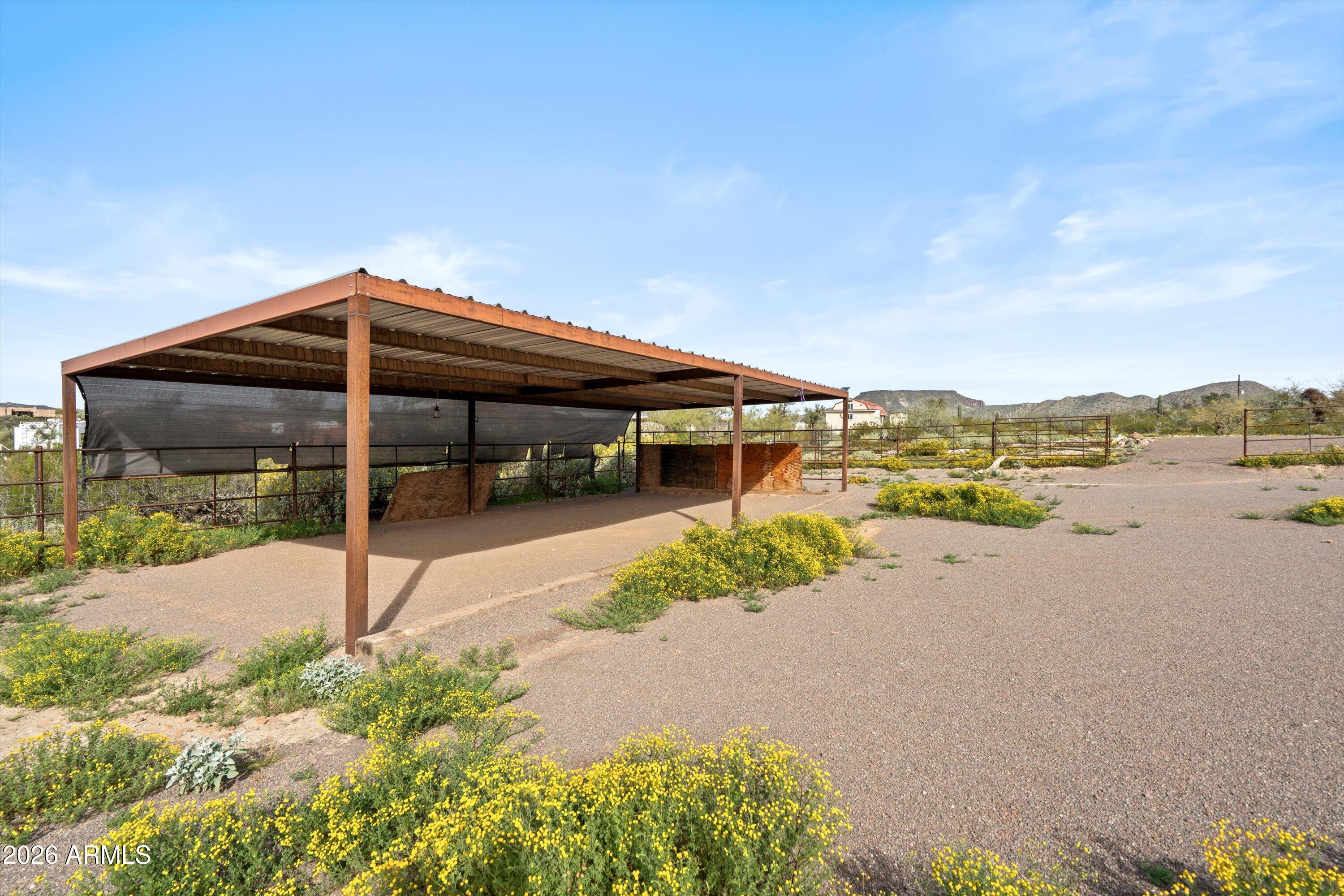 2316 West White Spar Road New River, AZ 85087 - Photo 36 of 40 a backyard of a house with table and chairs under an umbrella